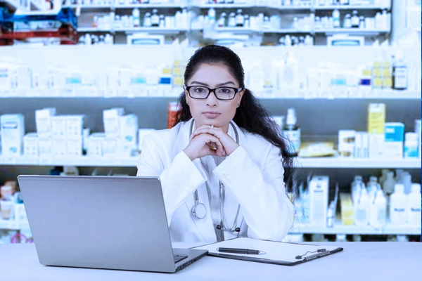 Farmacéutico seguro sentado en la farmacia —  Fotos de Stock