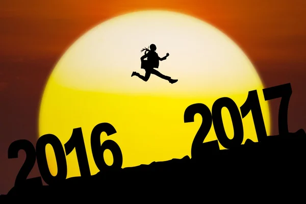 Молодой предприниматель прыгает с номера 2016 на 2017 — стоковое фото