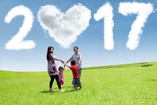 Famiglia che gioca sul campo con il cloud 2017 — Foto Stock