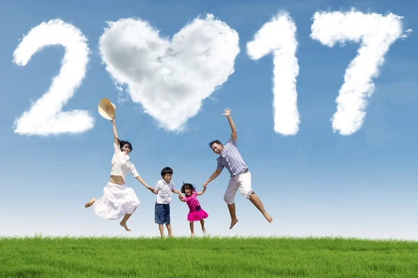 Lycklig familj hoppa på äng med 2017 — Stockfoto
