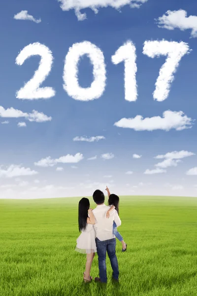 Happy family pointing cloud shaped number 2017 — Stock Photo, Image