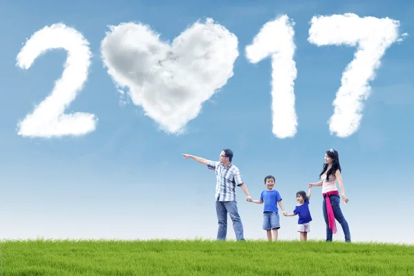 Happy family with cloud 2017 at field — Stock Photo, Image