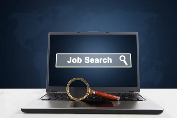 Laptop with magnifier and job search text — Stock Photo, Image