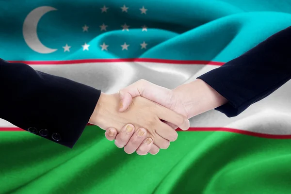 Équipe d'affaires à deux mains avec drapeau de l'Ouzbékistan — Photo