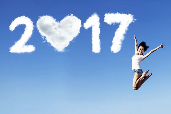 Woman and number 2017 on the blue sky — Stock Photo, Image