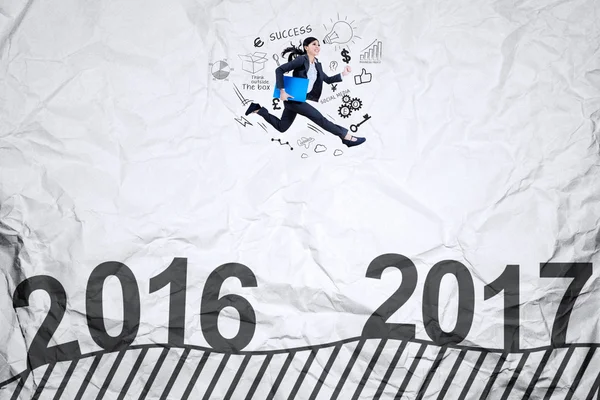 Woman jumps on crumpled paper with 2017 — Stock Photo, Image