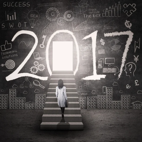 Woman stepping to the door of 2017 — Stock Photo, Image