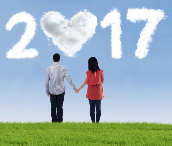 Junges Paar mit wolkenförmiger Nummer 2017 — Stockfoto