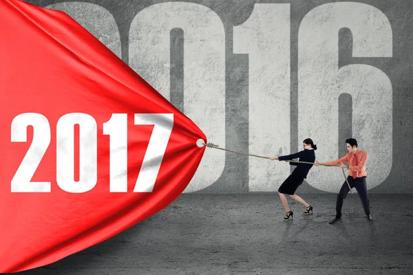 Business people pulling flag with 2017