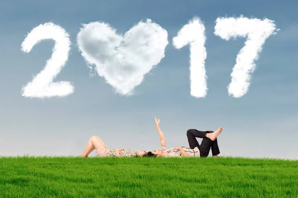 Pareja acostada sobre hierba con nube 2017 —  Fotos de Stock