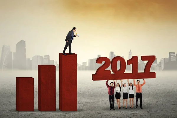 Empleados construyendo gráfico financiero 2017 — Foto de Stock