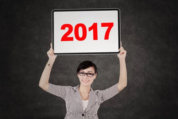 Schöne Unternehmerin hält Werbetafel mit 2017 — Stockfoto