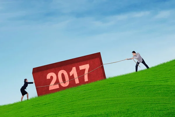 Trabajo en equipo intenta tirar de la roca con 2017 —  Fotos de Stock