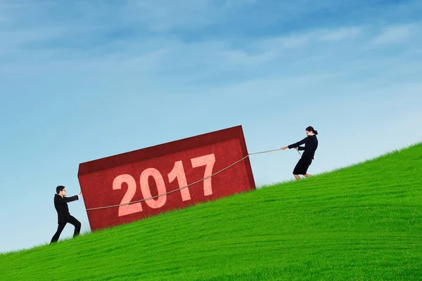 Dos trabajadores tirando de la roca con el número 2017 — Foto de Stock