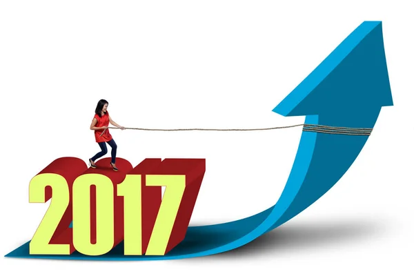 Beautiful woman pulling arrow with number 2017 — Stock Photo, Image