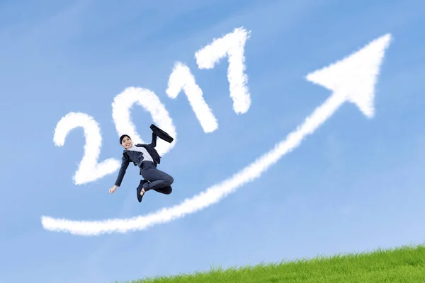 Businesswoman jumping on the meadow with cloud — Stock Photo, Image