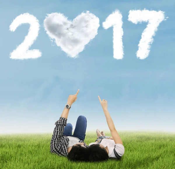 Couple pointing number 2017 on meadow — Stock Photo, Image