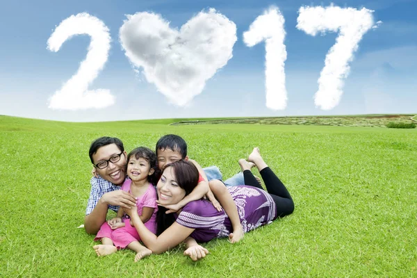 Jubelnde Familie im Gras liegend mit 2017 — Stockfoto