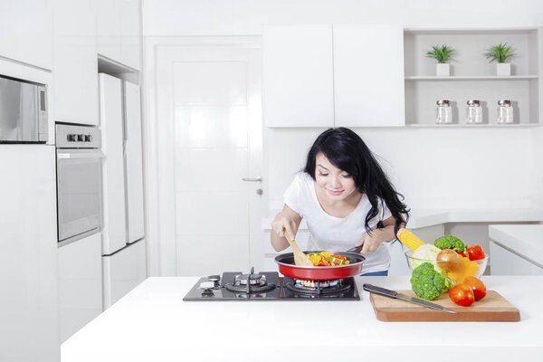 Woman sniffs meal on frying pan