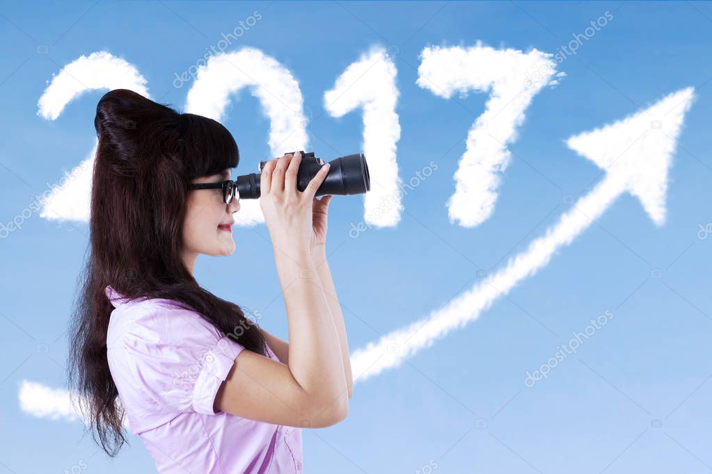 Woman looking at the sky with a telescope