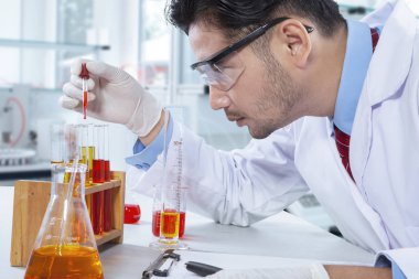 Kimyasal sıvı ile çalışan bilim adamı 