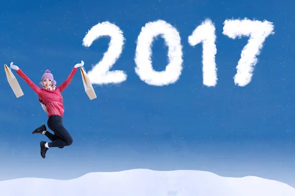 Attraktiv kvinna hoppa på himlen med 2017 — Stockfoto