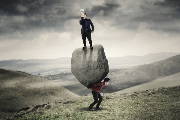 Businessman with megaphone above a stone and partner