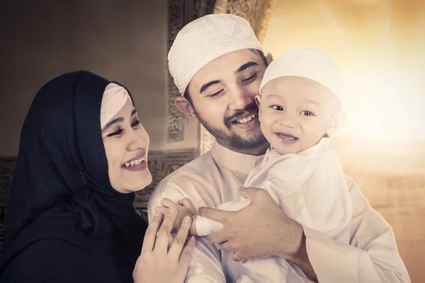 Moslim familie glimlachend op hun baby — Stockfoto