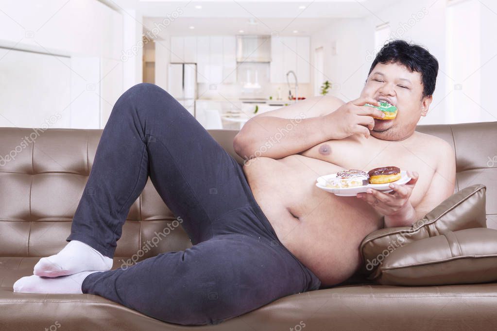 Fat man eats sweet food at home 