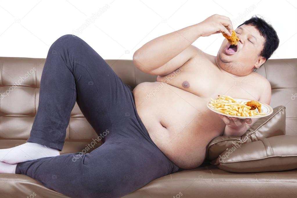 Greedy fat man eating junk food 
