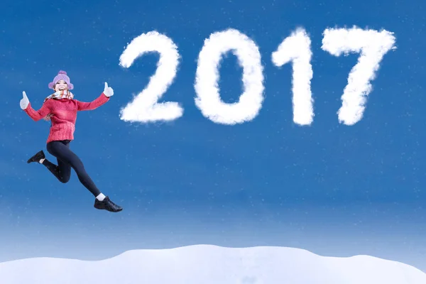 Frau springt mit 2017 auf blauem Himmel — Stockfoto