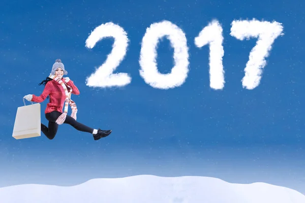 Woman leaps with 2017 on sky — Stock Photo, Image