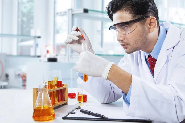 Químico joven hace prueba química en laboratorio —  Fotos de Stock