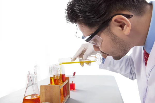 Científico joven mezclando líquido químico — Foto de Stock