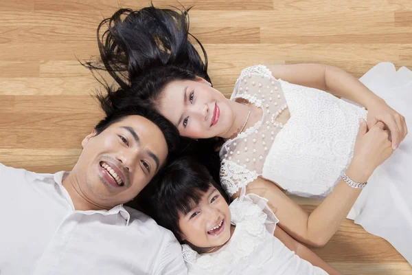Aantrekkelijke familie liggend op houten vloer — Stockfoto