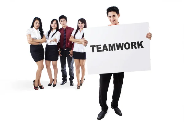 Equipe de negócios segurando um quadro com texto de trabalho em equipe — Fotografia de Stock