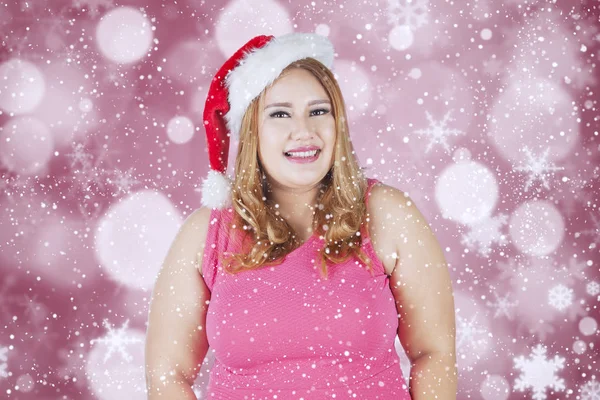 Donna grassa in cappello di Natale sorridente alla macchina fotografica — Foto Stock