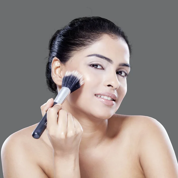 Female model using makeup brush