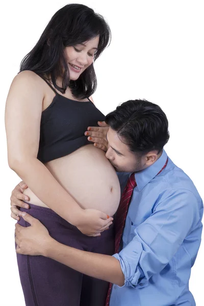 Муж целует беременный животик — стоковое фото