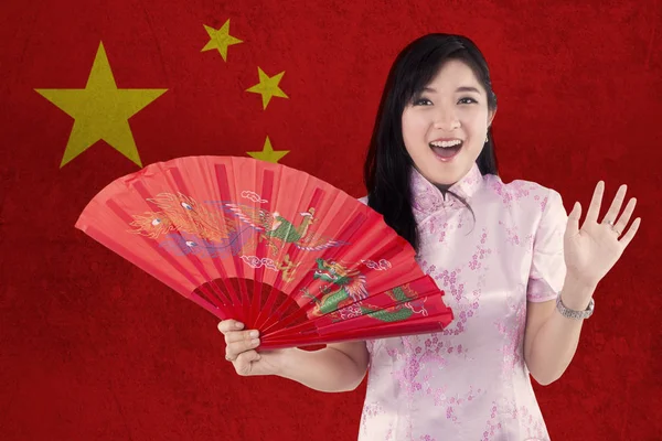 Menina alegre segura um fã com bandeira da China — Fotografia de Stock