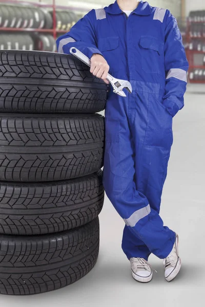 Técnico masculino com pilha de pneus — Fotografia de Stock