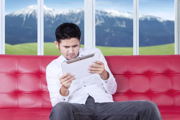 Mann auf Sofa surft mit Tablet im Internet — Stockfoto