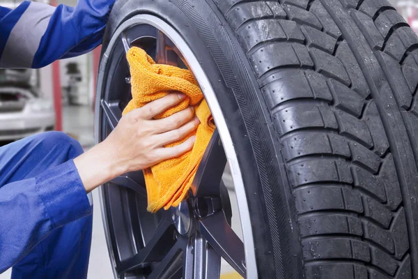 Mechanic with felly and cloth in the workshop — Stock Photo, Image