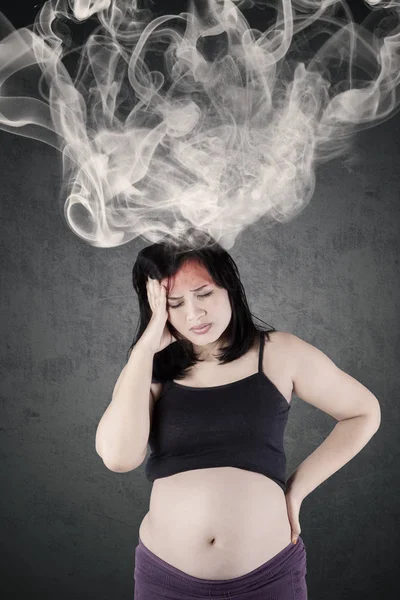 Mãe grávida sente dor de cabeça com fumaça — Fotografia de Stock
