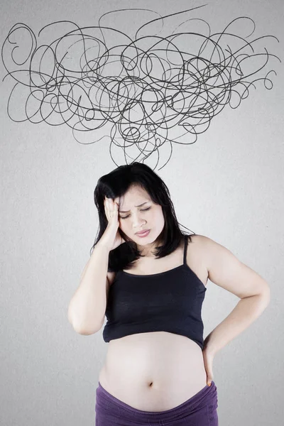 Gravid kvinna med vridna pilar på vägg — Stockfoto