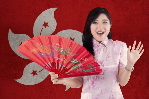 Bella ragazza tiene un ventilatore con la bandiera di Hong Kong — Foto Stock