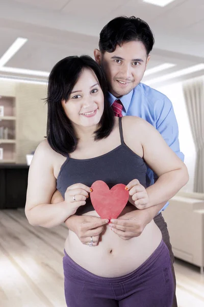 Casal sorridente segurando símbolo de coração — Fotografia de Stock