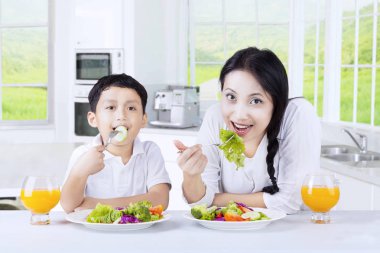 Anne ve oğlu salata mutfakta yemek