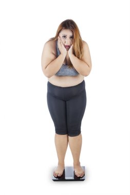 Ağırlık ölçek üzerinde duran obez kadın 