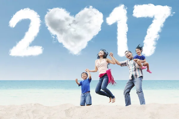 Rodina skočit na pláži s cloud 2017 — Stock fotografie